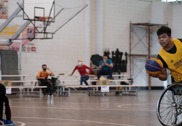 Dynamic wheelchair basketball game showcasing skill and determination indoors.