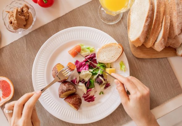 Top view of a nutritious breakfast setup with salad, bread, and fresh juice, perfect for a healthy start.